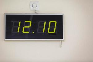 reloj digital negro sobre un fondo blanco que muestra la hora doce horas diez minutos foto