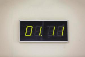 Black digital clock on a white background showing time 01. 11 photo