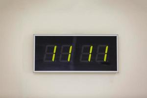 Black digital clock on a white background showing time eleven hours eleven minutes photo