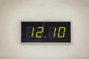 reloj digital negro sobre un fondo blanco que muestra la hora doce horas diez minutos foto