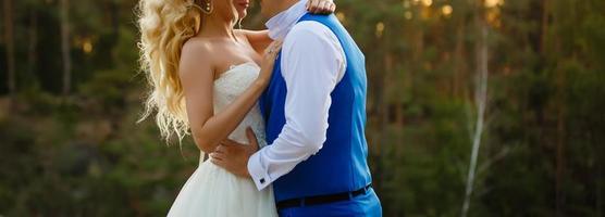 Beautiful Bride and groom wedding couple at marriage day outdoors on the mountains rock on sea background. Happy marriage couple outdoors on nature, soft sunny lights. photo