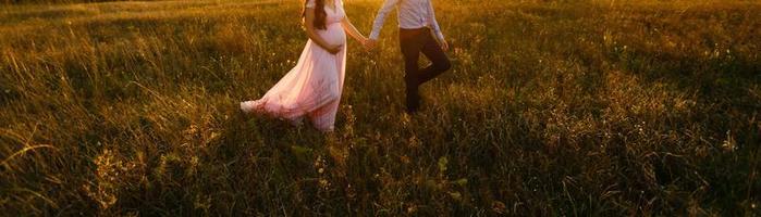 beautiful pregnant girl and her husband in the nature photo