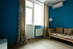 Modern interior of room with armchair on blue wall background photo