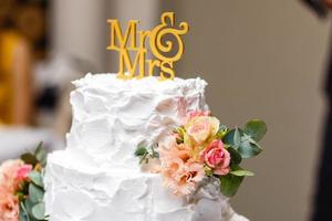 a multi level white wedding cake on a silver base and pink flowers on top photo