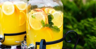 limonada fría y refrescante de cítricos en tarros de albañil con naranja, lima y limón