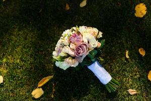 wedding flowers, wedding bouquet, bouquet of peach, dairy roses and white flowers lying on yellow autumn leaves, wedding ceremony, come autumn, time of year, the grass photo