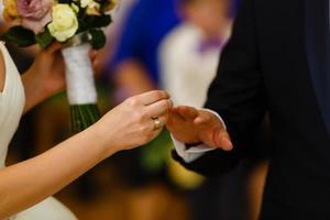 día de la boda. el novio coloca el anillo en la mano de la novia. primer plano de la foto