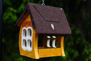 knitted from yarns birdhouse hanging in the park photo