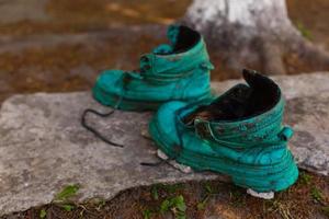 zapato viejo cubierto de musgo en un bosque primaveral. imagen abstracta viejos zapatos verdes foto