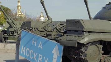 Blue road sign with white letters near the tank, on the territory of the National Museum of the History of Ukraine. Russia's war against Ukraine. Translation, To Moscow.
