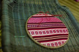 The wooden hoop with the embroidery pattern of red and Black color on canvas. Slavic Embroidery with hemming. photo