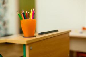 lápices de colores en vidrio en el escritorio con poca profundidad de campo