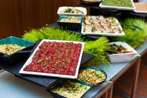 grupo de personas catering comida buffet interior en restaurante de lujo con carne coloridas frutas y verduras foto