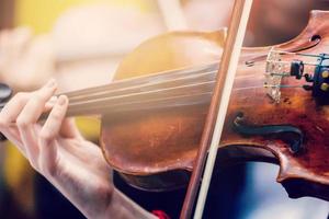 The hand of the girl playing the violin in dark colors photo