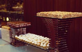 Selection of decorative desserts on a buffet table at a catered luxury event or celebration photo