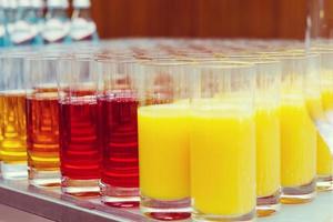 food background. many glasses with natural juice with orange on buffet table photo