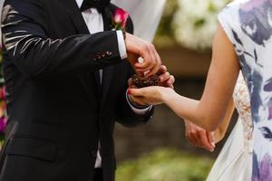 la novia y el novio intercambian anillos durante una ceremonia de boda, una boda en el jardín de verano foto