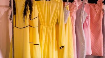 Pastel colorful dresses hang on the pegs photo