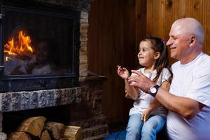 Grandfather and granddaughter playing Grandfather and little girl fireplace photo