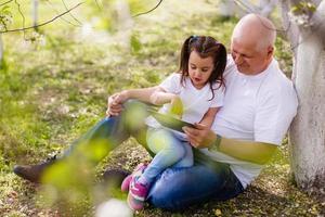 grandfather and his little granddaughter together in garden photo