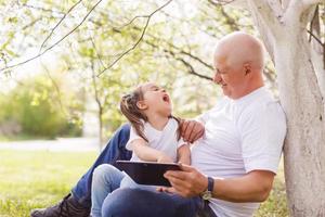 grandfather and his little granddaughter together in garden photo