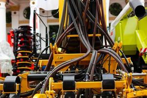 Close up of pipe system of hydraulic valves in agricultural machinery photo