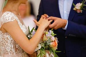 los recién casados intercambian anillos, el novio pone el anillo en la mano de la novia en la oficina de registro matrimonial