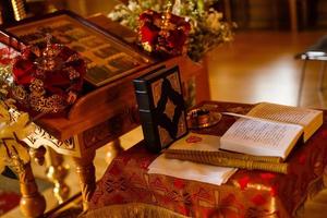 libros de la iglesia y otros atributos de la ceremonia de bautizo del niño foto