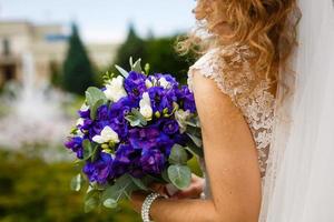 ramo de novia azul con flores blancas en las manos de la novia. foto