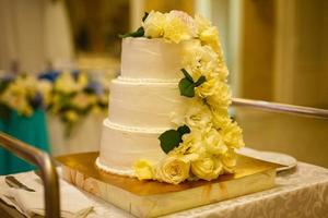 White wedding cake with real roses decorations photo