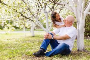 abuelo y su nieta juntos en el jardín foto