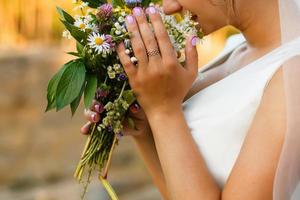 Summer wedding bouquet made of chamomile flowers in hand photo