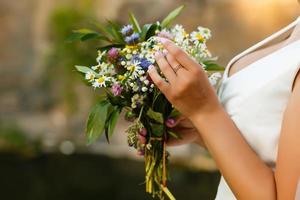 Summer wedding bouquet made of chamomile flowers in hand photo