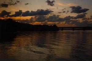 hermosa puesta de sol río reflejo de nubes agua foto