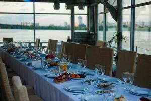 Sparkling glassware stands on long table prepared for wedding dinner photo