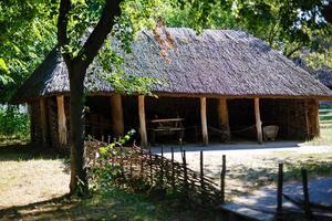 old house covered with straw under blue sky in ukranian village photo