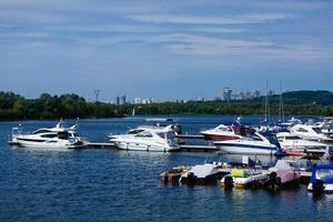 Boats anchored on the bank of the river, across the river residential houses, wide river, rest place photo