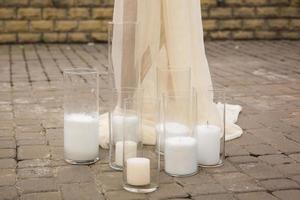 Candles in the glass on the background of a stone wall photo