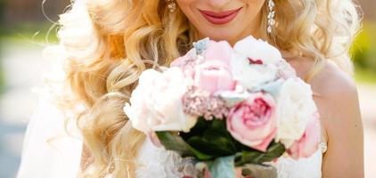 ramo de boda en manos de la novia, rico ramo de peonía de melocotón y crema y flor de rosas, enfoque selectivo. foto