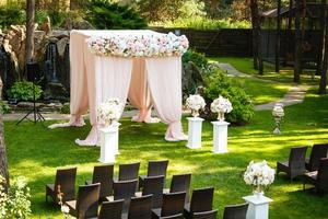 hermosos elementos de decoración de diseño de ceremonia de boda con arco, diseño floral, flores y sillas. foto