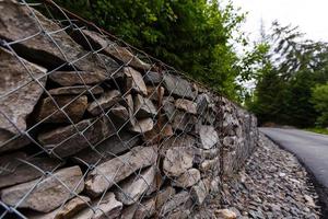 Slope and earth retention wall management with rocks and wire mesh cage system in tropical hilly terrain photo