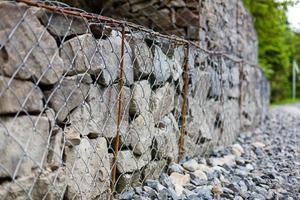 gestión de taludes y muros de contención de tierra con rocas y sistema de jaulas de malla de alambre en terreno montañoso tropical foto