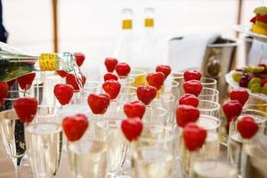 Waiter Standing With Champagne Glasses Next To Arranged Wedding Table photo