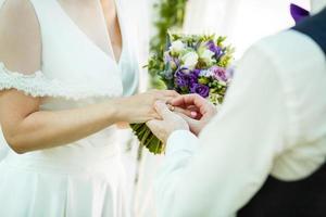 The bride and groom exchange rings during a wedding ceremony, a wedding in the summer garden photo