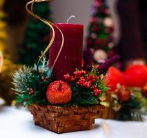 Candle decorated with cinnamon sticks and red apples, christmas decoration photo