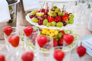 decoración de frutas de mesa de boda en el restaurante, piña, fresa, uva foto
