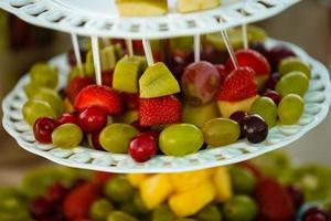 decoración de frutas de mesa de boda en el restaurante, piña, fresa, uva foto