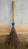 A broom stick leaning against the outside wall of the house photo