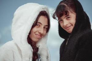 Two beautiful sisters with winter clouds behind them, photo in Egypt 2023