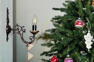 Candle-style lamp in a candelabra near the Christmas tree photo